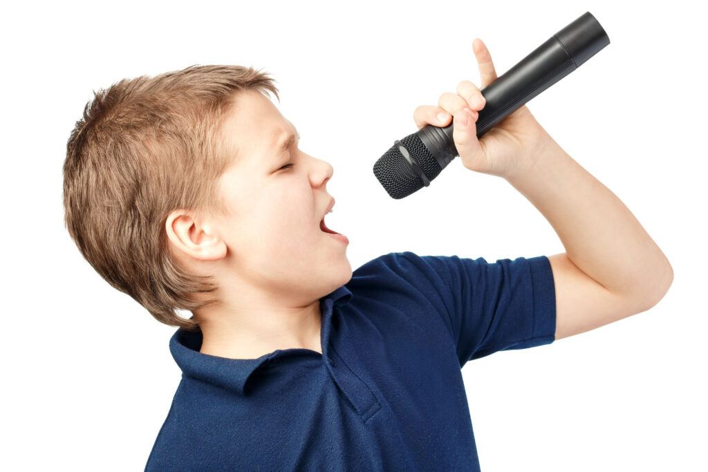 Boy singing into a microphone. Very emotional.